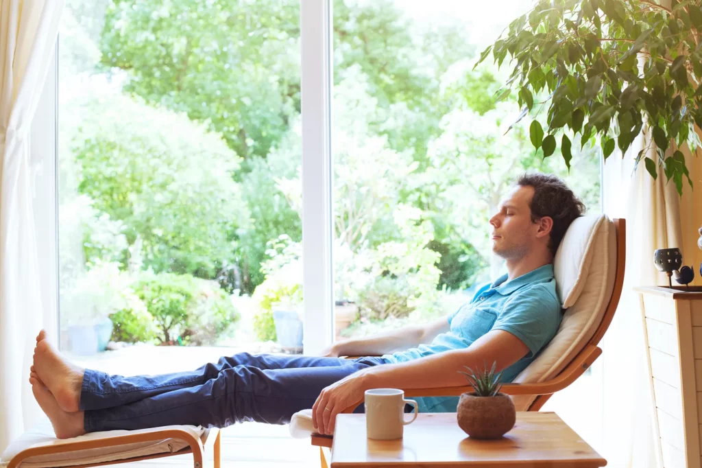 man relaxing on a lounger indoors on a hot day
