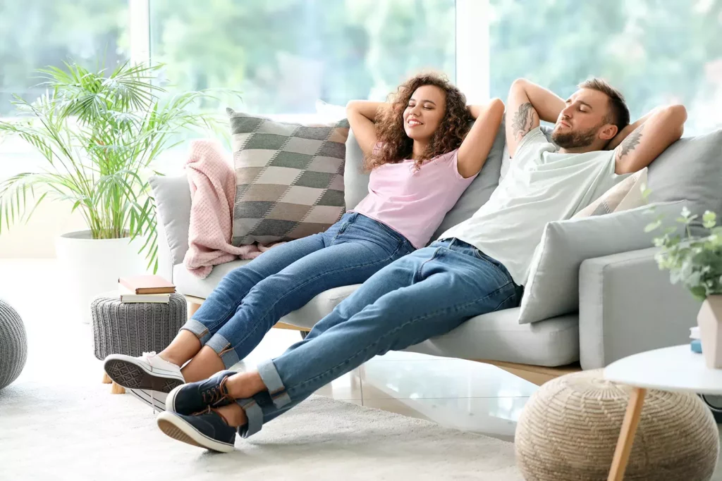 two people comfortable on a couch
