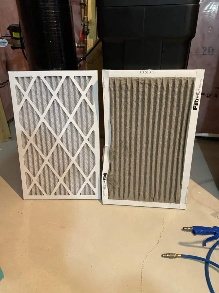 Two furnace air filters side-by-side for comparison on a concrete floor against a home HVAC setup background. On the left is a clean, white pleated air filter, and on the right is a used, dirty filter with noticeable dust and discoloration, both labeled Filtrete. This image serves as a visual representation of the importance of regular air filter replacement for maintaining indoor air quality and system efficiency.