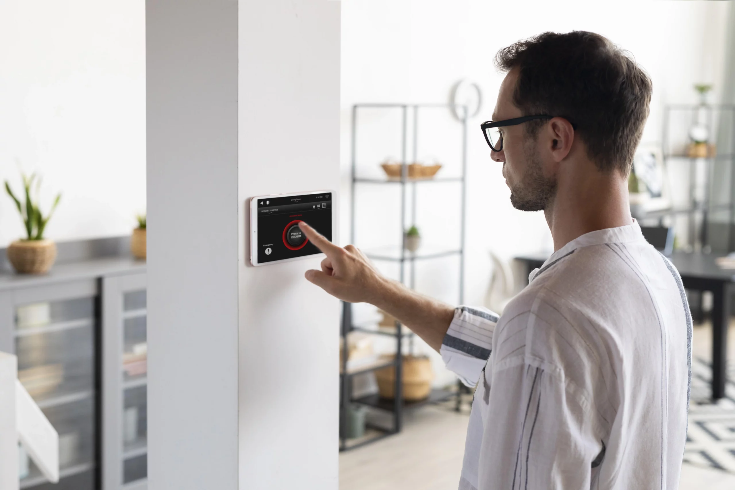 a man using a wall mounted touch screen thermostat