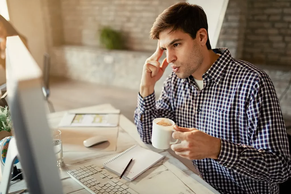 gentleman thinking while holding a coffee thinking about getting an AC Tune Up